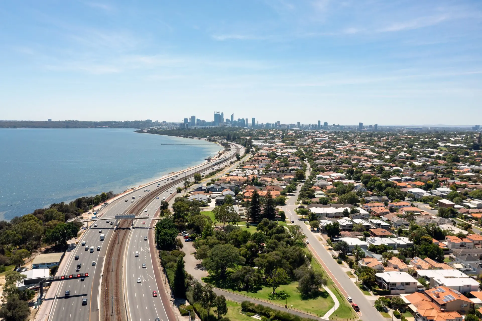 Coastal highway passes through city and ocean view.