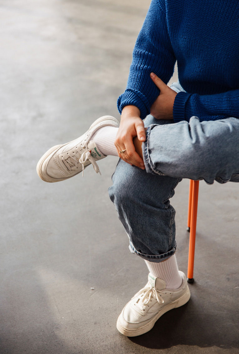 Person sits on a stool in the workshop room