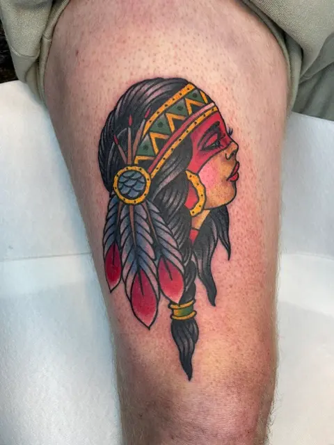 Traditional-tatuering med indiankvinna och fjädrar på lår, High Heels Tattoo Västervik