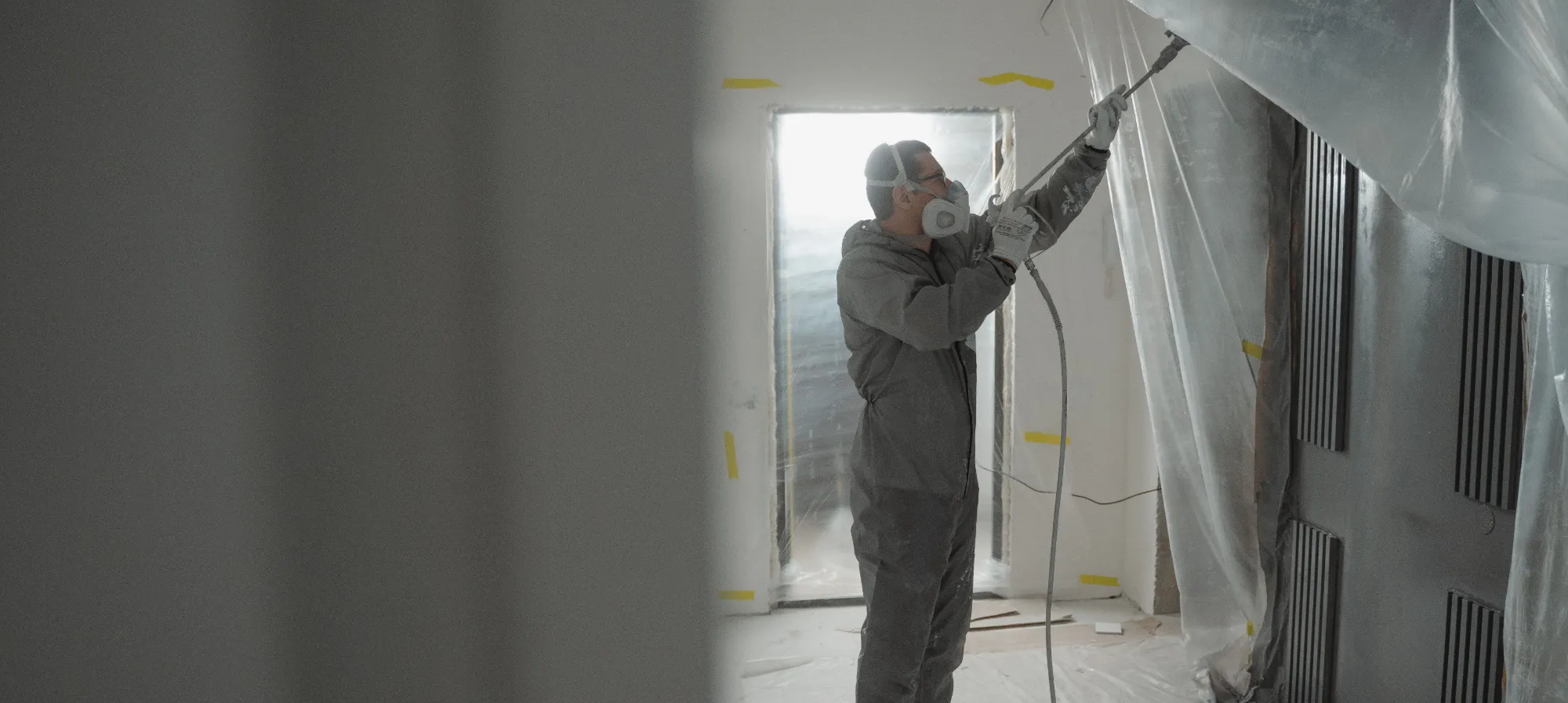 A painter spraying the interior of a house.