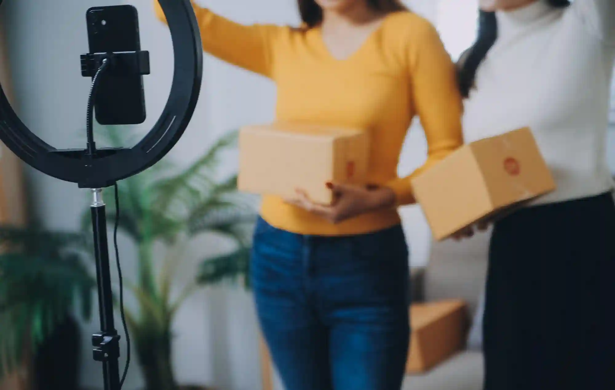Two women preparing e-commerce packages for shipping.