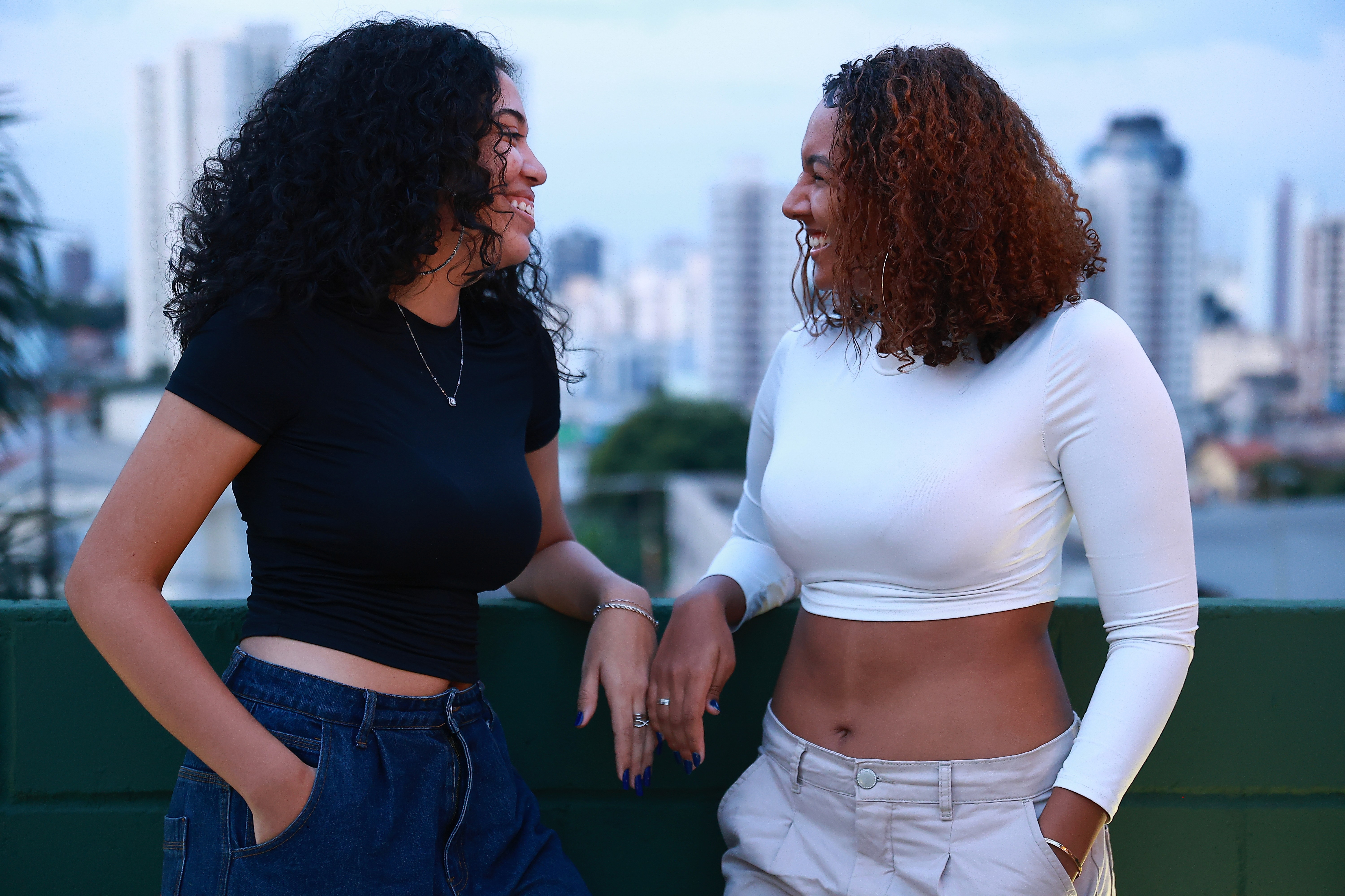 woman holding a phone and man looking at the phone. both are smiling