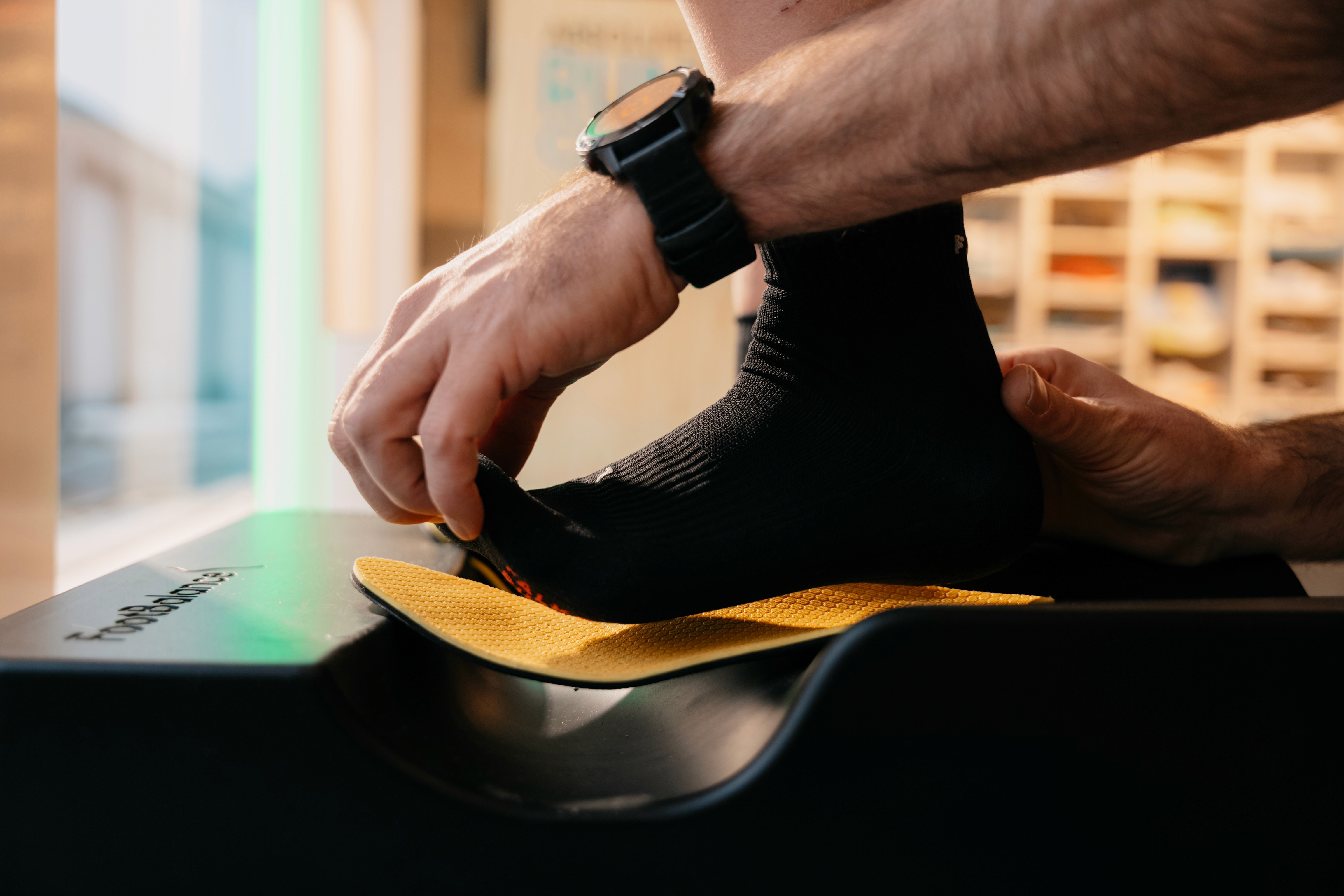 Four diverse professionals collaboratively working on a laptop, with one person pointing at the screen while others observe.
