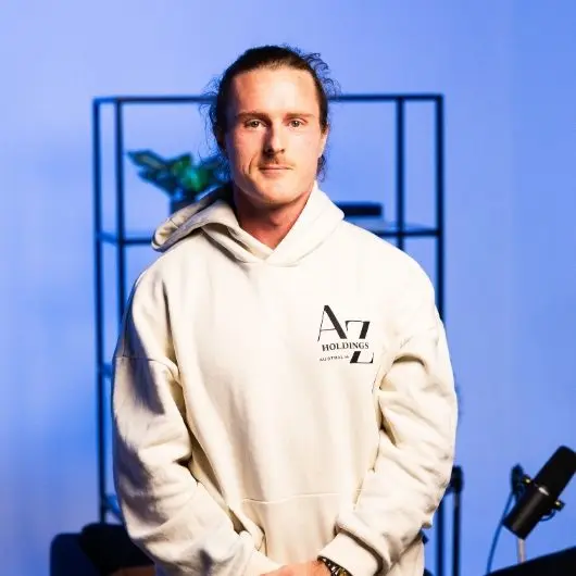 Man in cream hoodie with logo