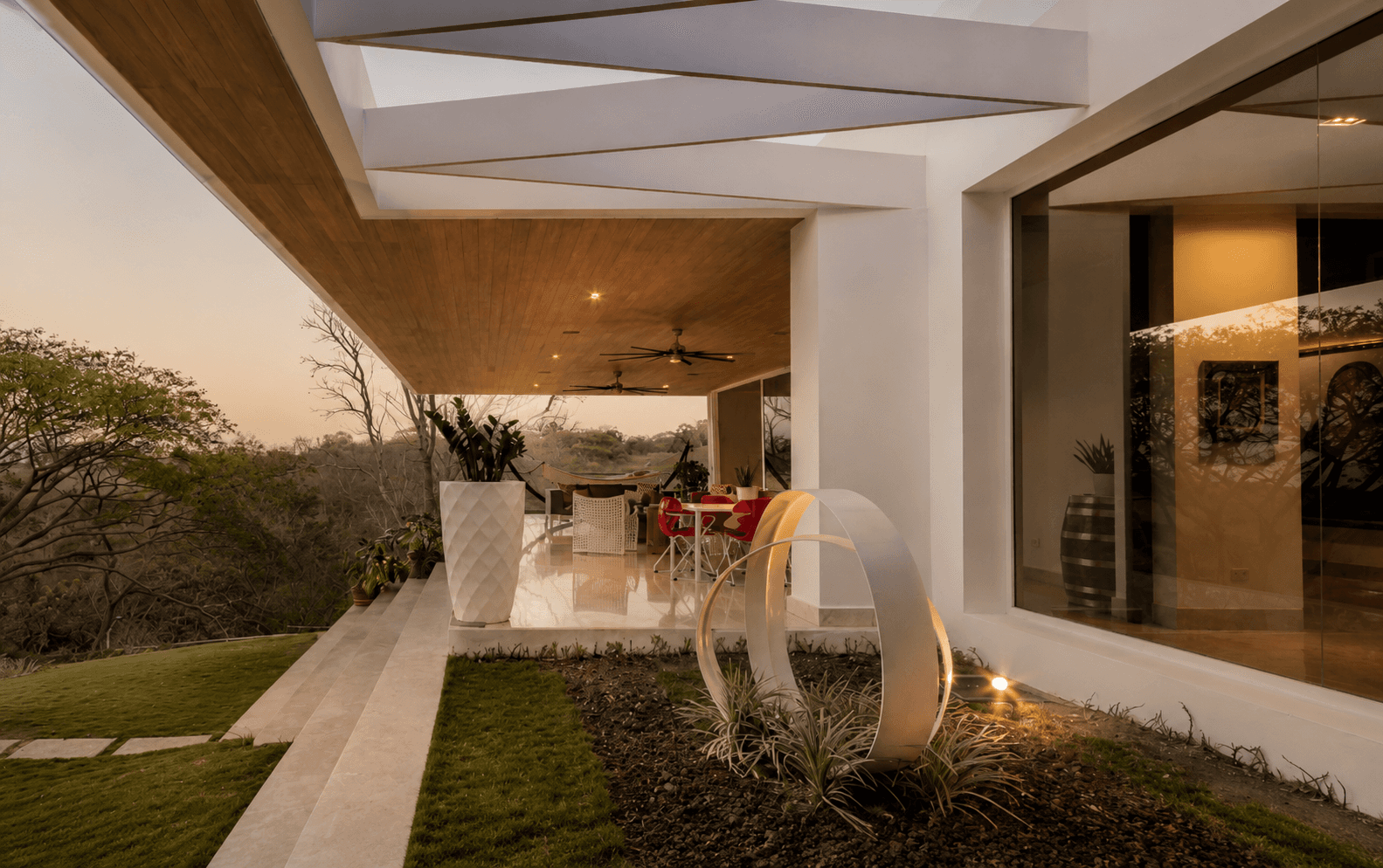 Open living terrace with full-height glazing and garden views — Floating Hill House by Hurtado Arquitectos