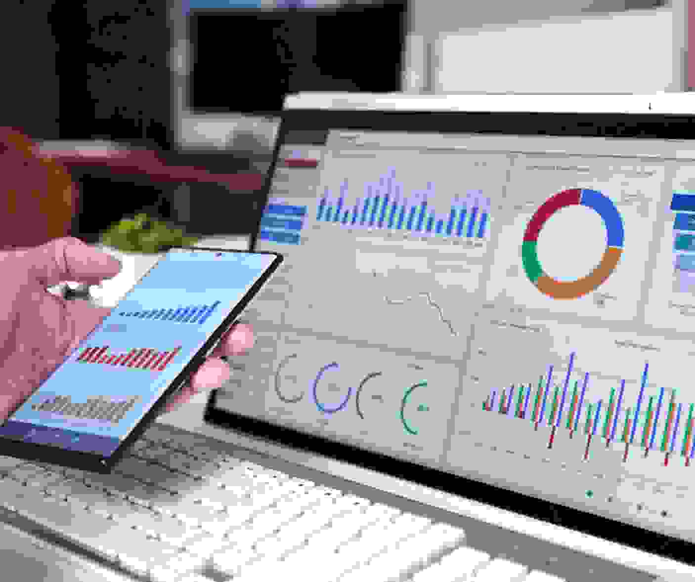 Laptop and smartphone displaying analytics dashboards with charts and graphs representing data-driven insights.