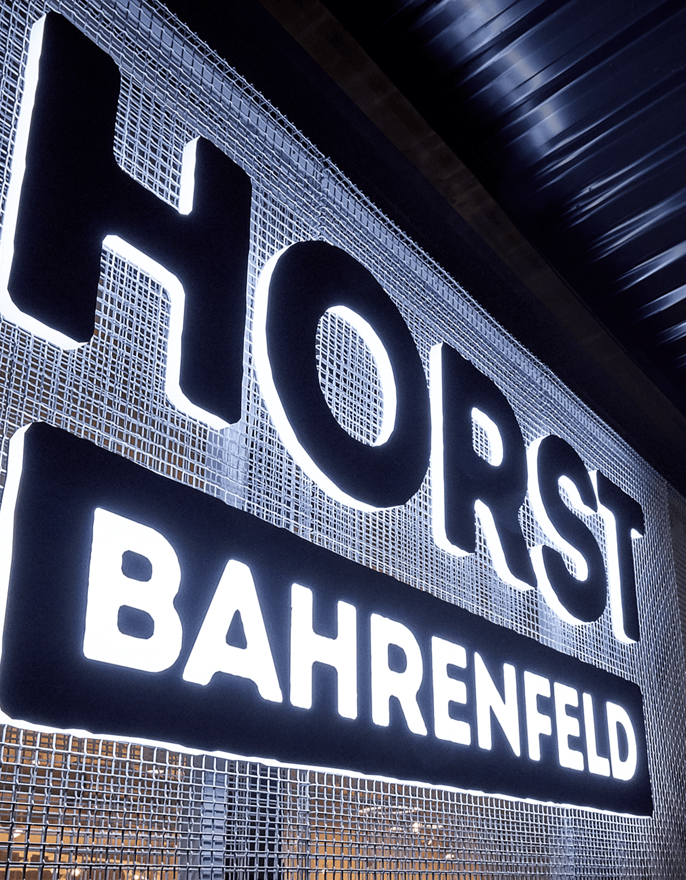 Nachtaufnahme des ersten tegut… teo in Fulda, warm beleuchtet und mit einer Schlange wartender Kund:innen vor dem Eingang.