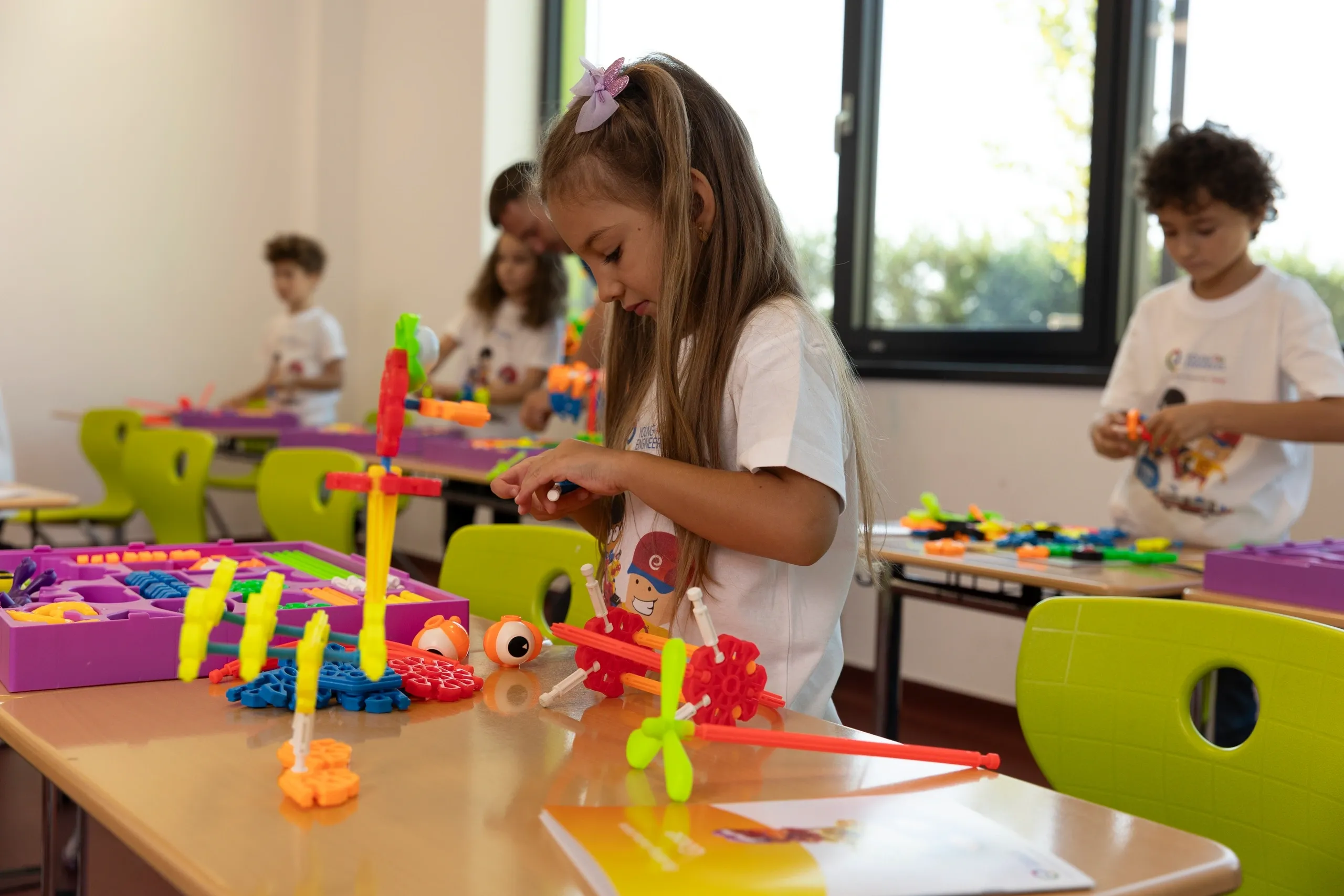 Petite fille participant à un atelier de création robotique avec des kits colorés Young Engineers à Montréal.
