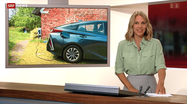 SRF News anchor reporting on electric vehicles, with an image of a car charging, highlighting the growing adoption of electromobility and sustainable transportation solutions in Switzerland