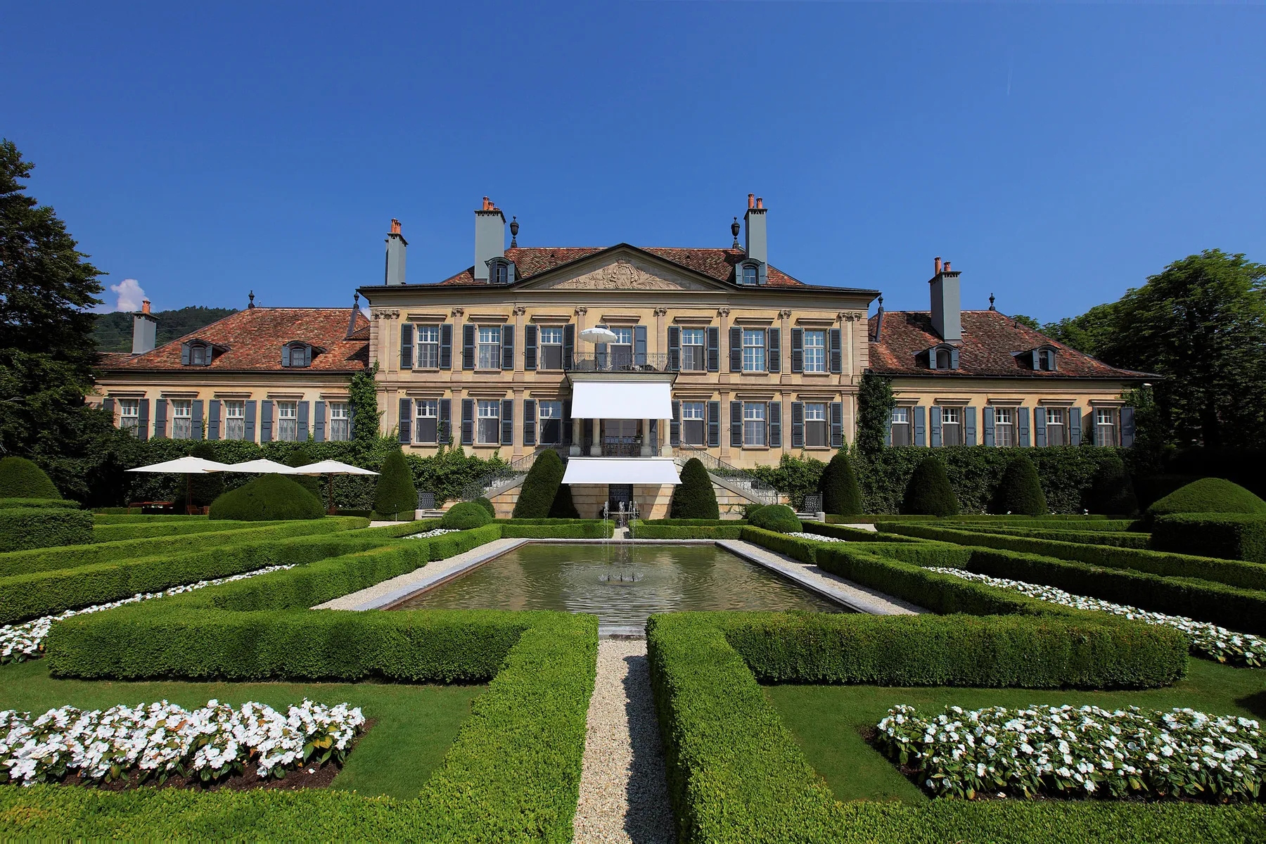 A mansion with symmetrical architecture and formal landscaped garden