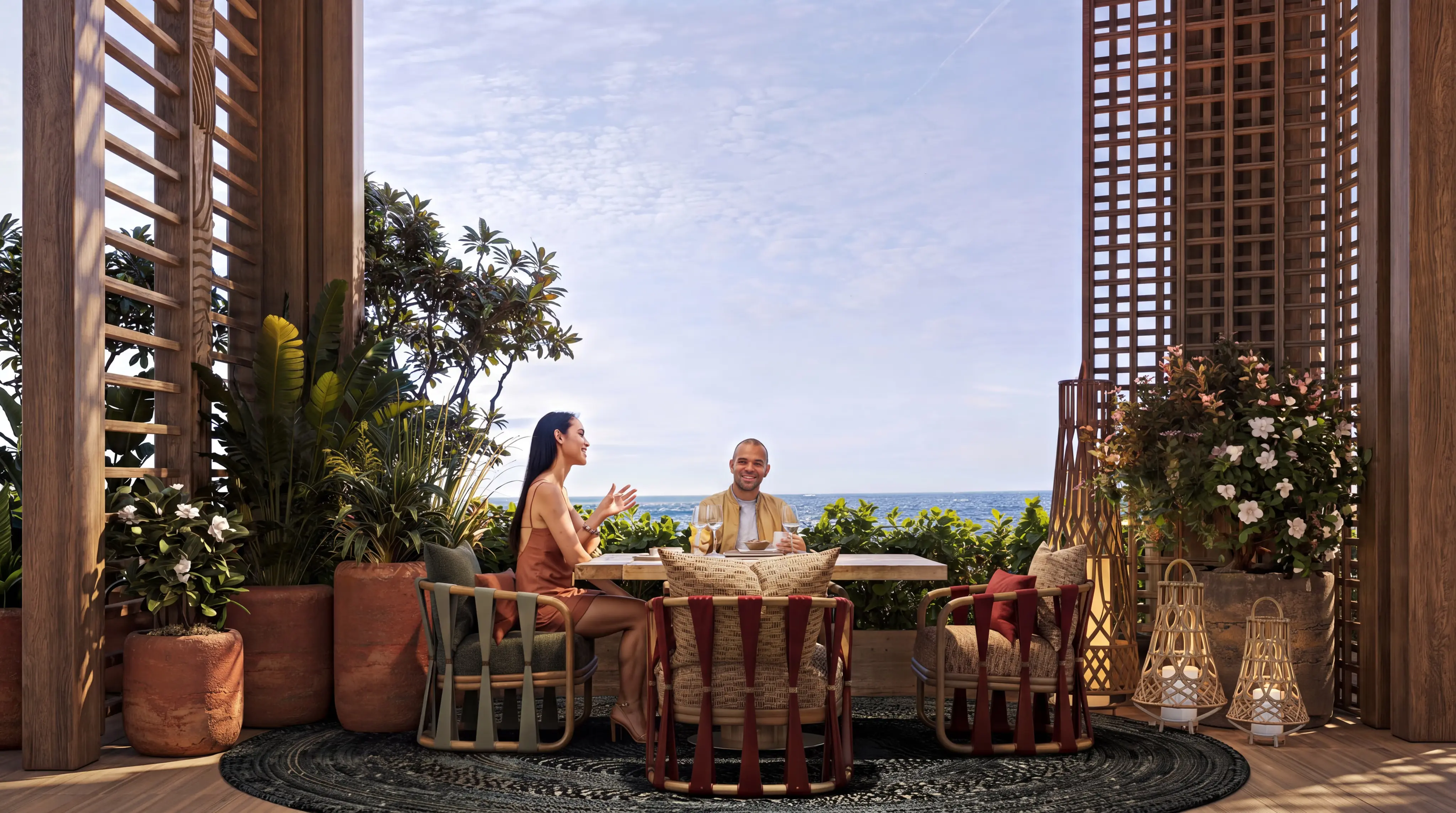 Guests dining on Alnaeim’s ocean-facing terrace, framed by lattice screens and potted plants.