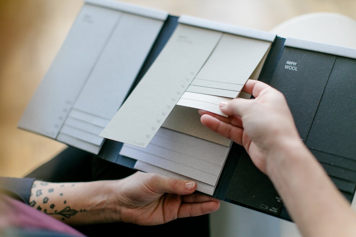 Auswahl von Papier- und Farbmustern für ein Designprojekt mit verschiedenen Grauabstufungen