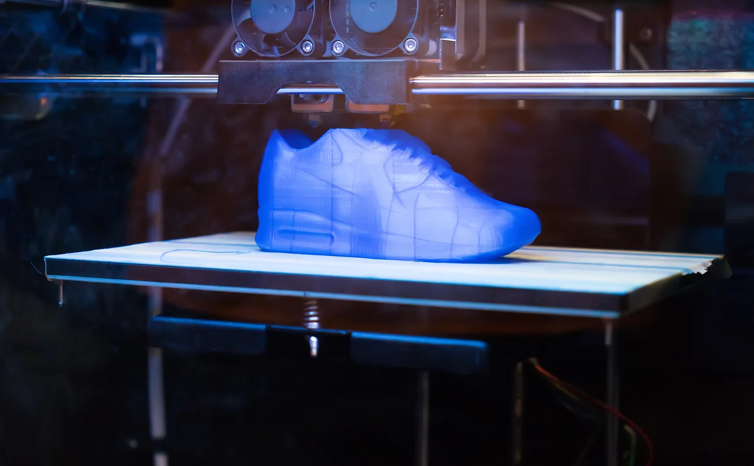 A 3D printer fabricating a prototype of a shoe consumer product.