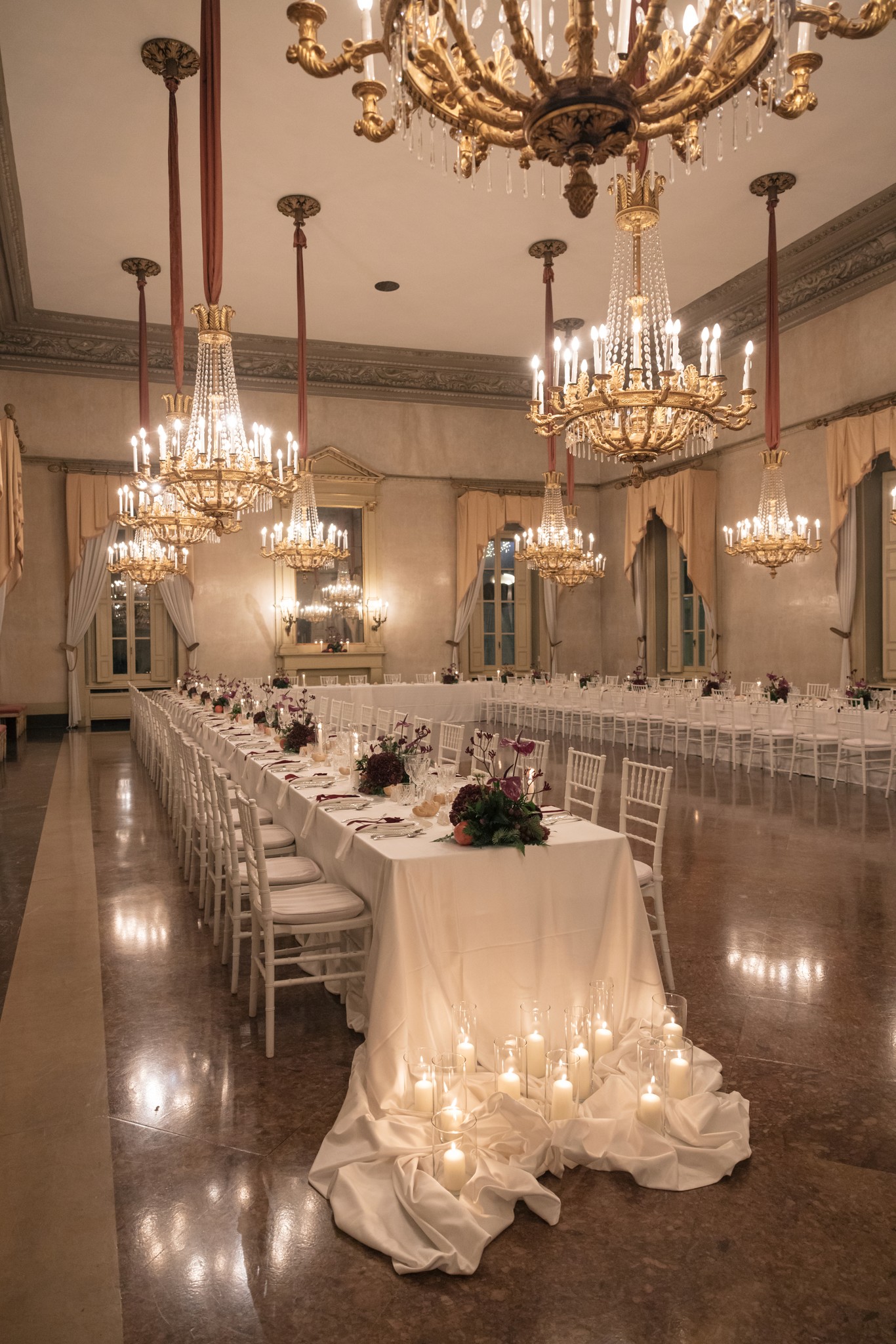 Sala ricevimento matrimonio al Circolo di Lettura a Parma, tavoli eleganti illuminati da lampadari in cristallo e candele