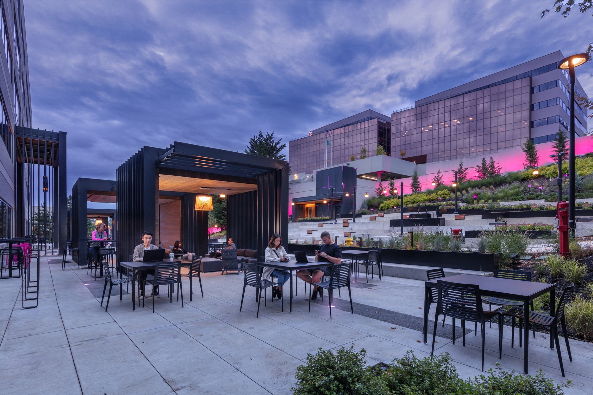 People enjoying a vibrant courtyard with diverse amenities, reflecting T-Mobile's innovative and people-first culture.