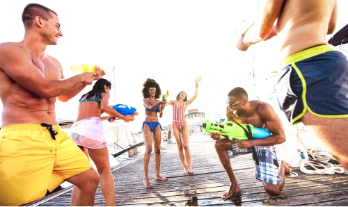 A group of friends playing with water guns together, having fun during the day.