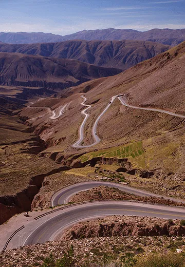 Estrada em curvas fechadas atravessando paisagem montanhosa e árida no noroeste da Argentina