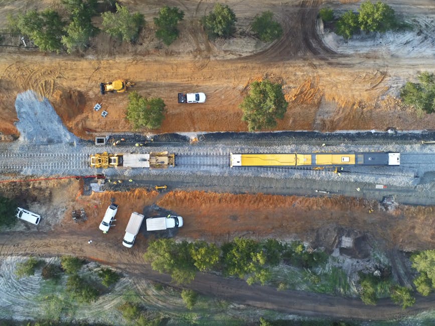 Aerial view of a construction site with machinery and railway tracks in Sines, Portugal.