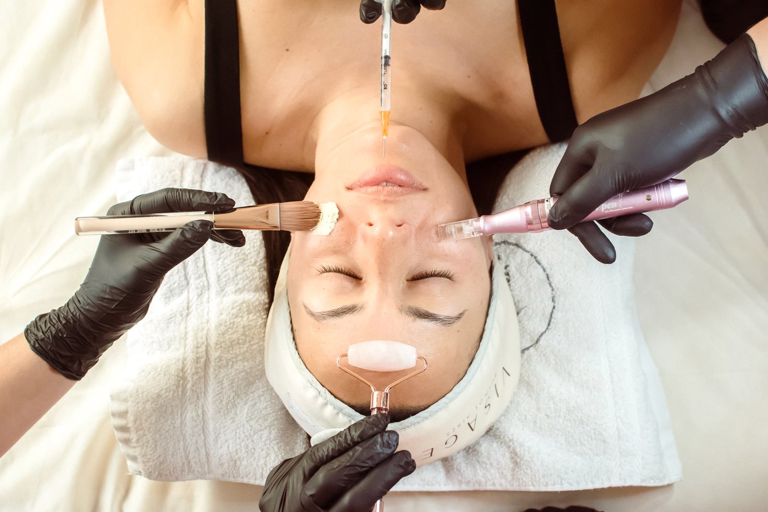 A serene and elegant spa space with wooden reclining chairs and white cushions. Golden sunlight filters through a cascading water feature, creating a peaceful atmosphere. Tropical plants and candles add to the relaxing ambiance.