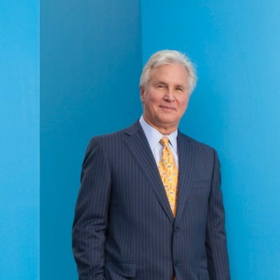 Bob Greczyn in suit, waist up photo in front of blue background