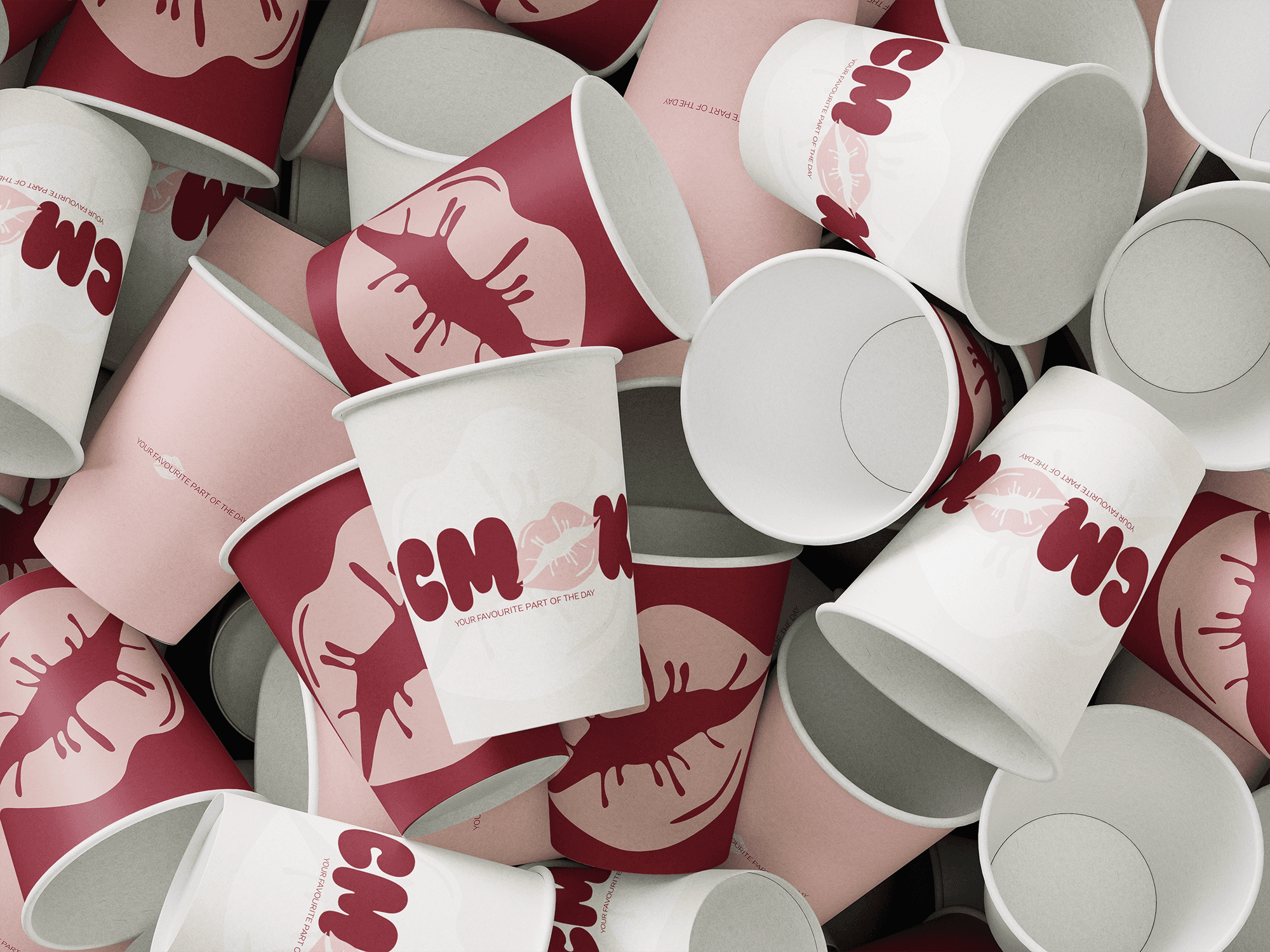 Scattered CMOK paper cups in burgundy, pink and cream.