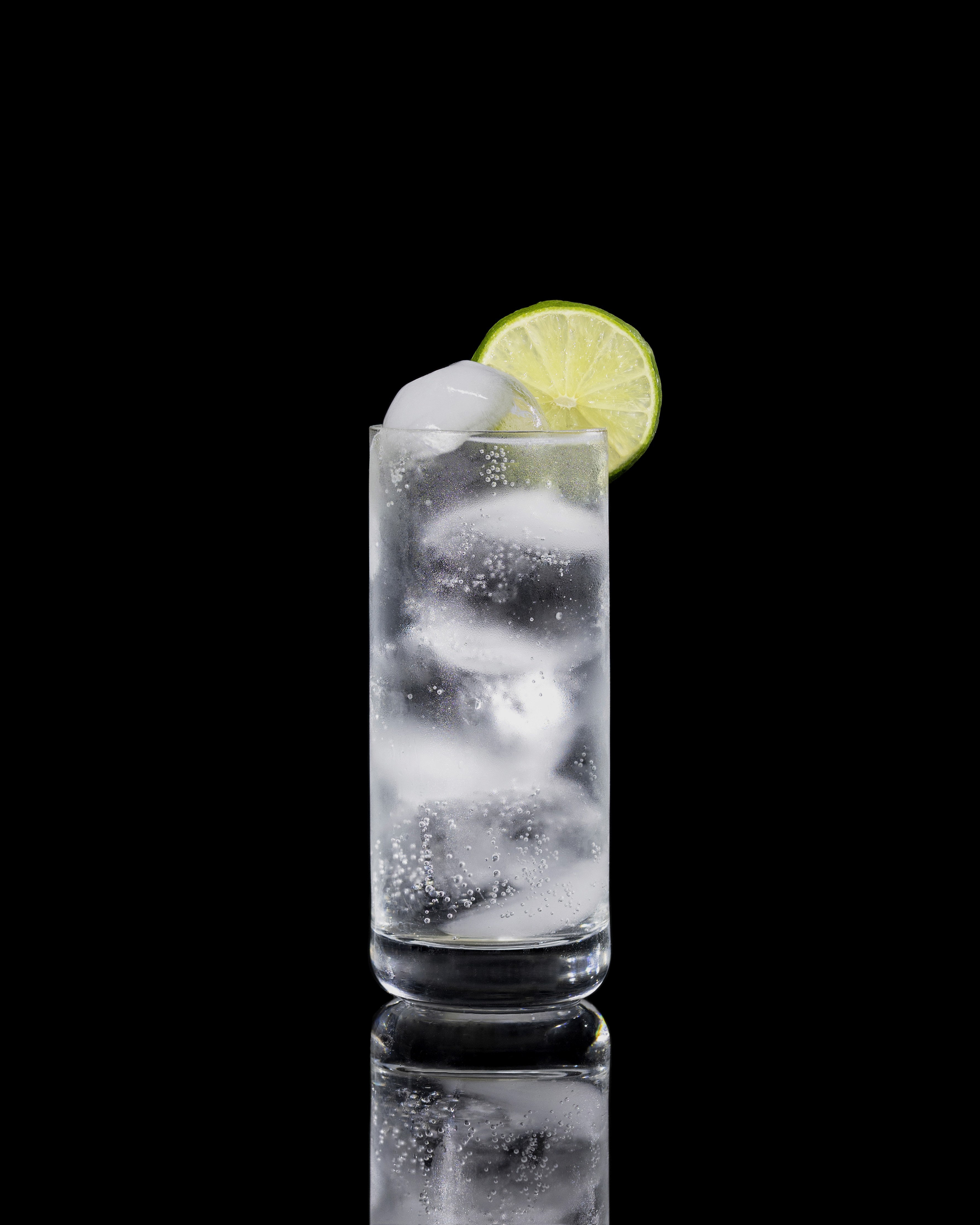 A closeup of a Vodka Soda drink against a dark background.