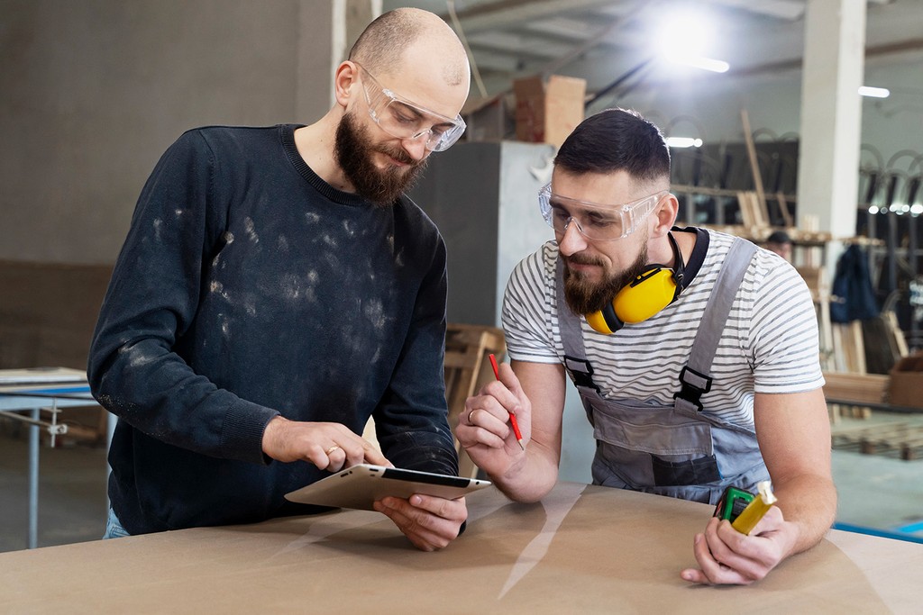 two men in construction looking at a notepad