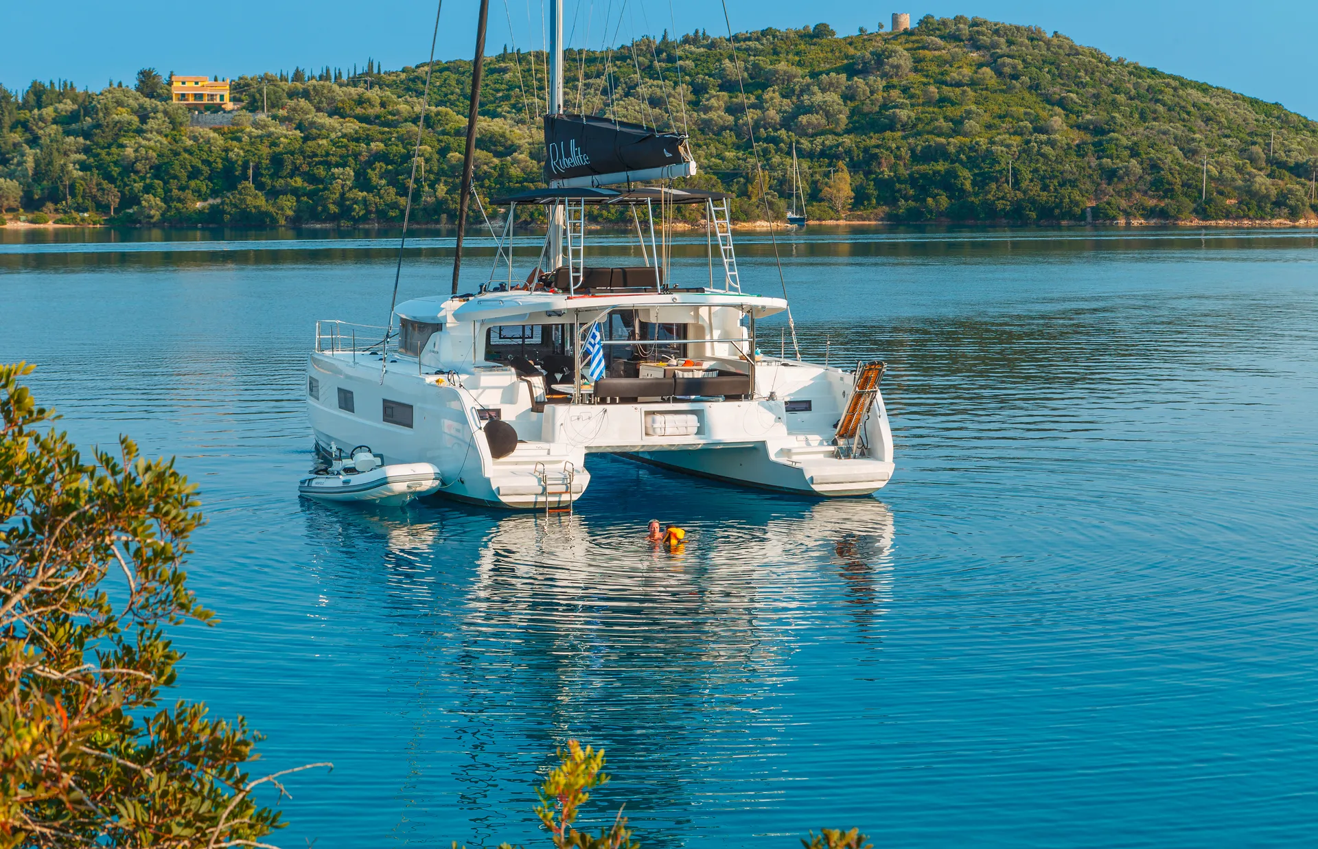 White Rock 36 speedboat with captain at helm cruising calm blue waters near Paros coastline with hills in background.