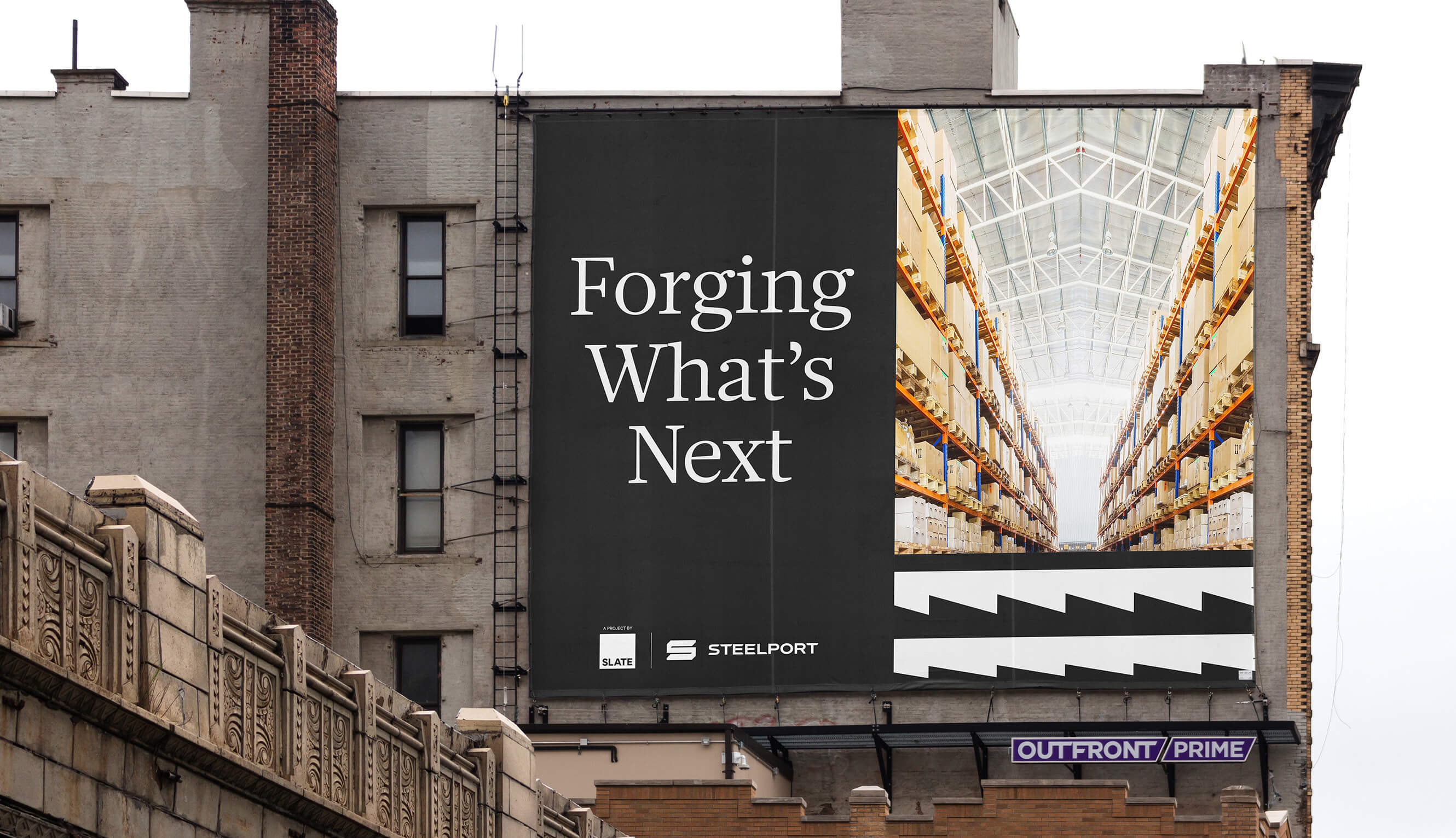 A billboard on the outside of a building, with text that reads "Forging What's Next"