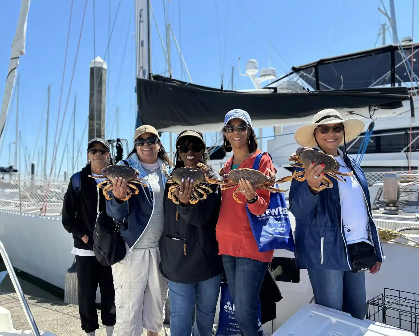 A group of women holding a seattle dungenes crab