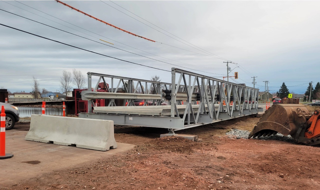 Temporary modular bridge carrying traffic over the culvert replacement trench in Shippagan, New Brunswick