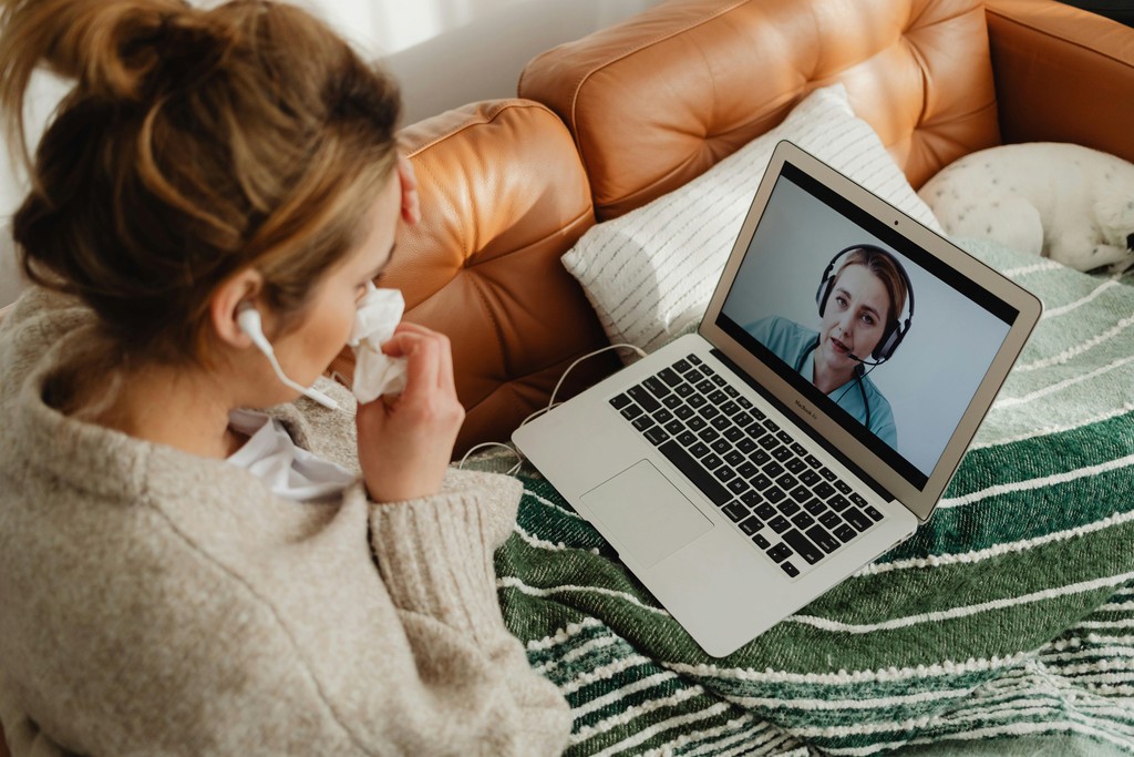 Newcomer having a virtual healthcare video consultation with a Canadian doctor to avoid walk-in clinic wait times.