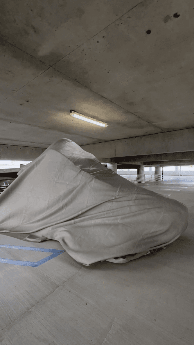A Jordan sneaker draped in a heavy white fabric in a parking garage