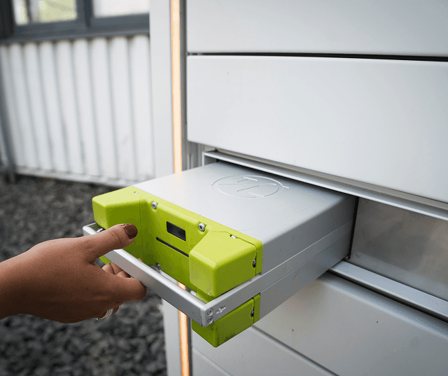 Person inserting a battery into a solar energy storage unit.