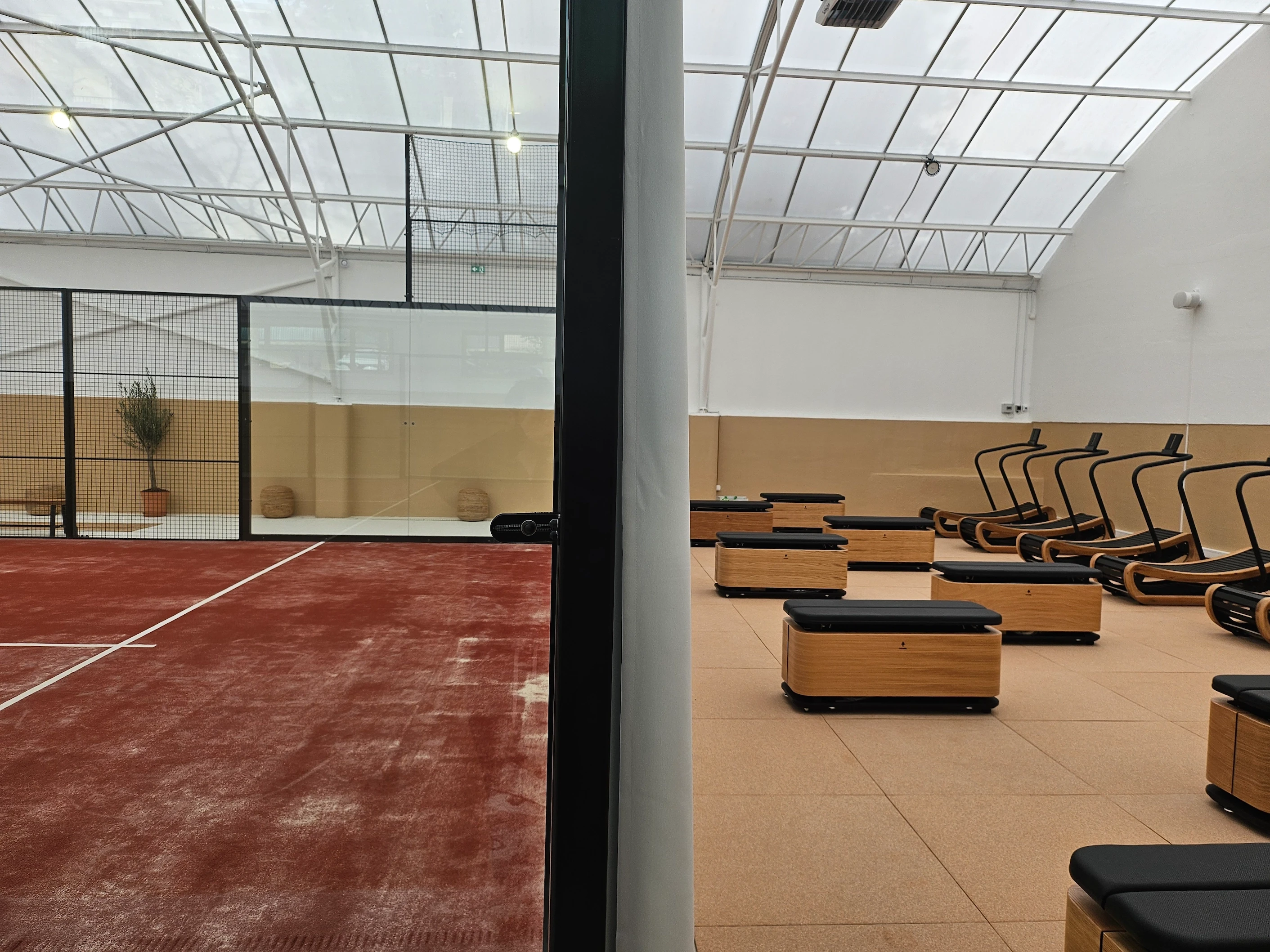Terrain de padel et espace fitness moderne, vue intérieure.