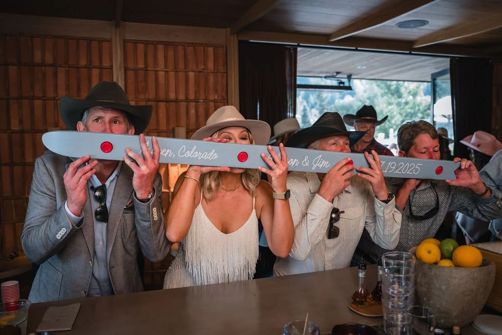 Guests holding a personalized ski during the reception