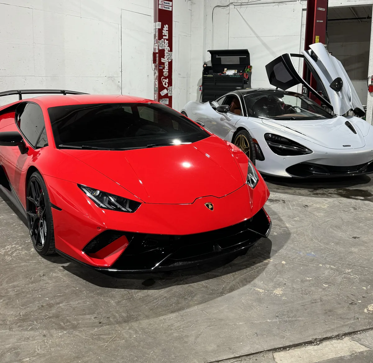 Red Lamborghini Huracán and a McLaren in the 714 Technik service bay