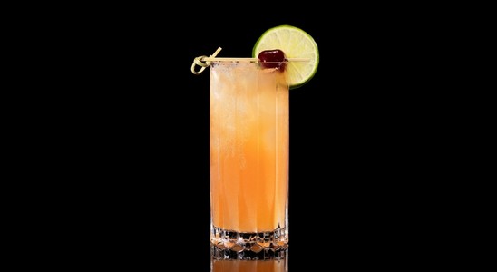 A closeup of a Bay Breeze drink against a dark background.