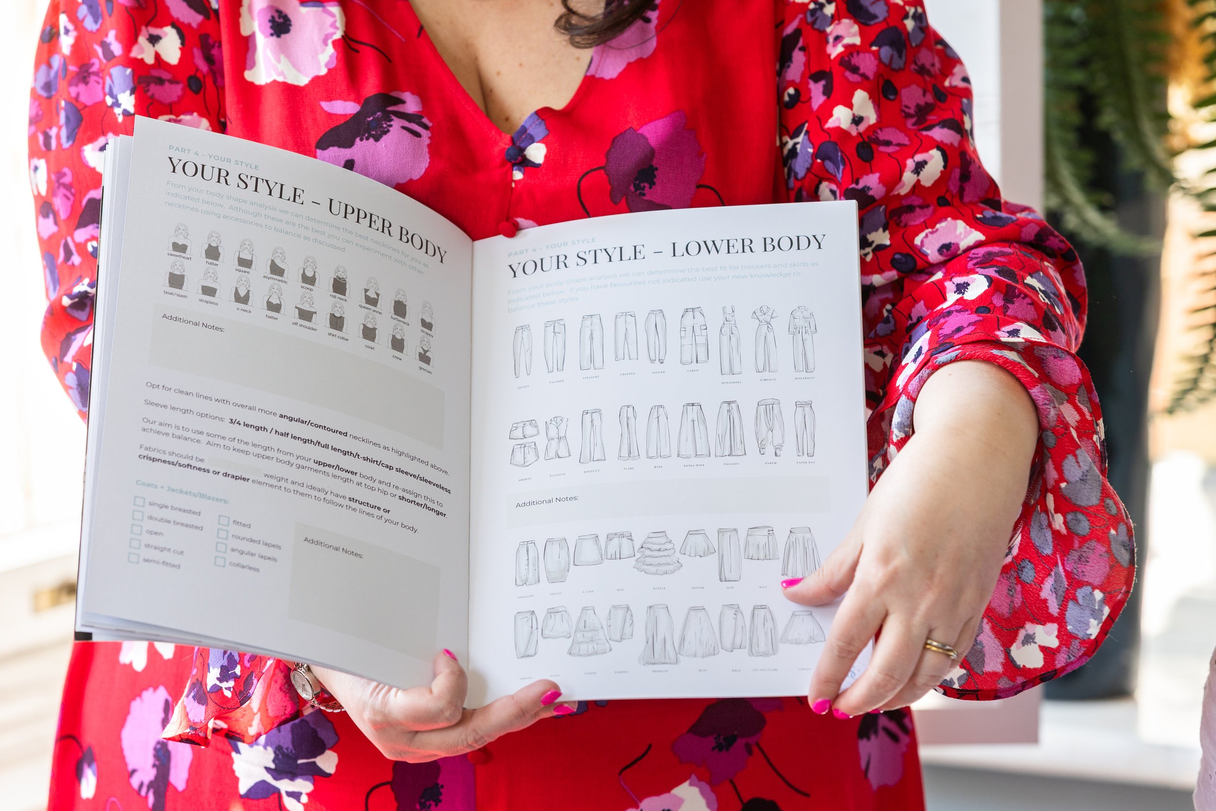 A woman in a red floral dress holds open a style guide, showing illustrated charts for upper and lower body shapes, helping clients choose clothing that suits their natural silhouette
