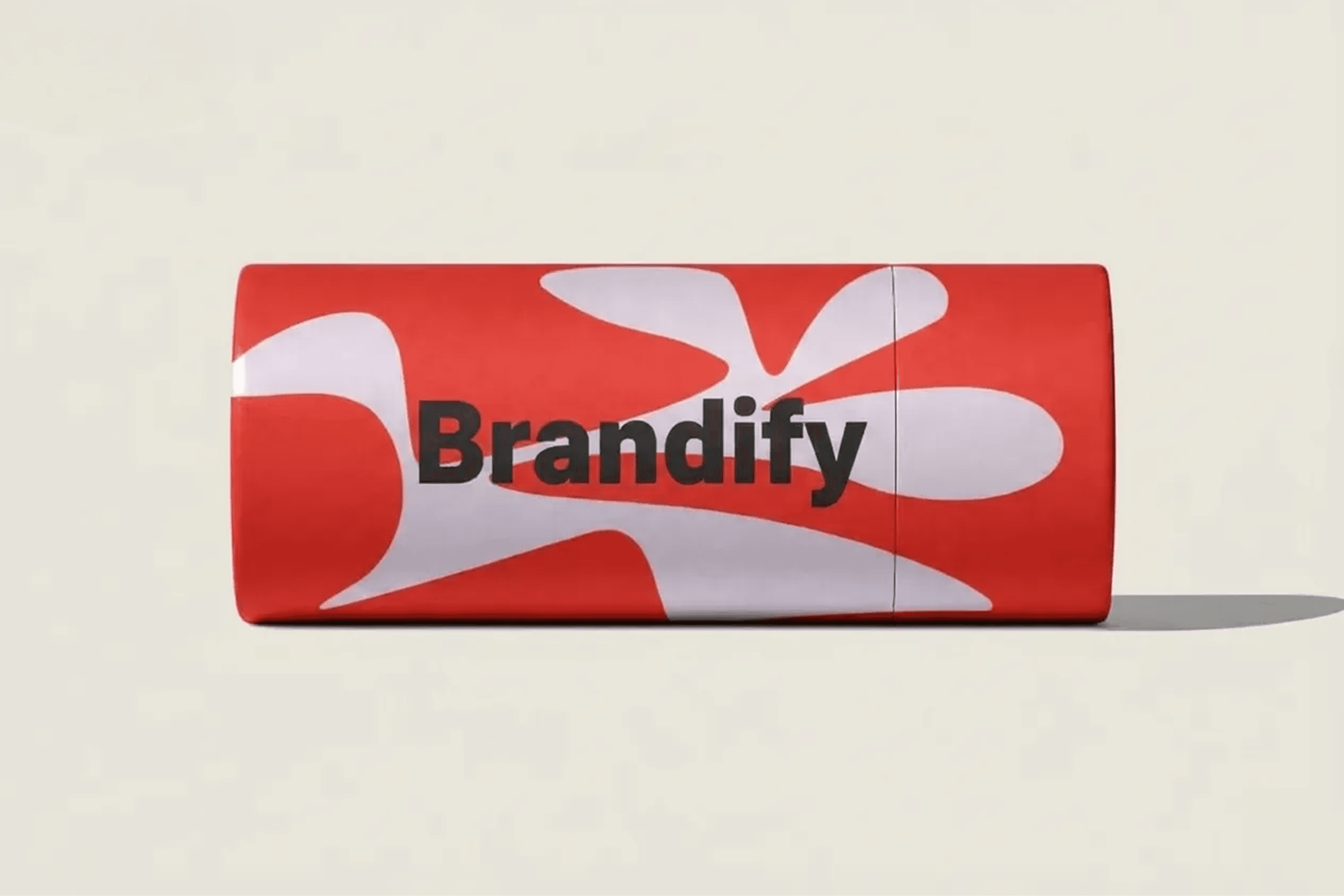 A cylindrical package with a red background and white abstract shapes features the black text "Brandify."