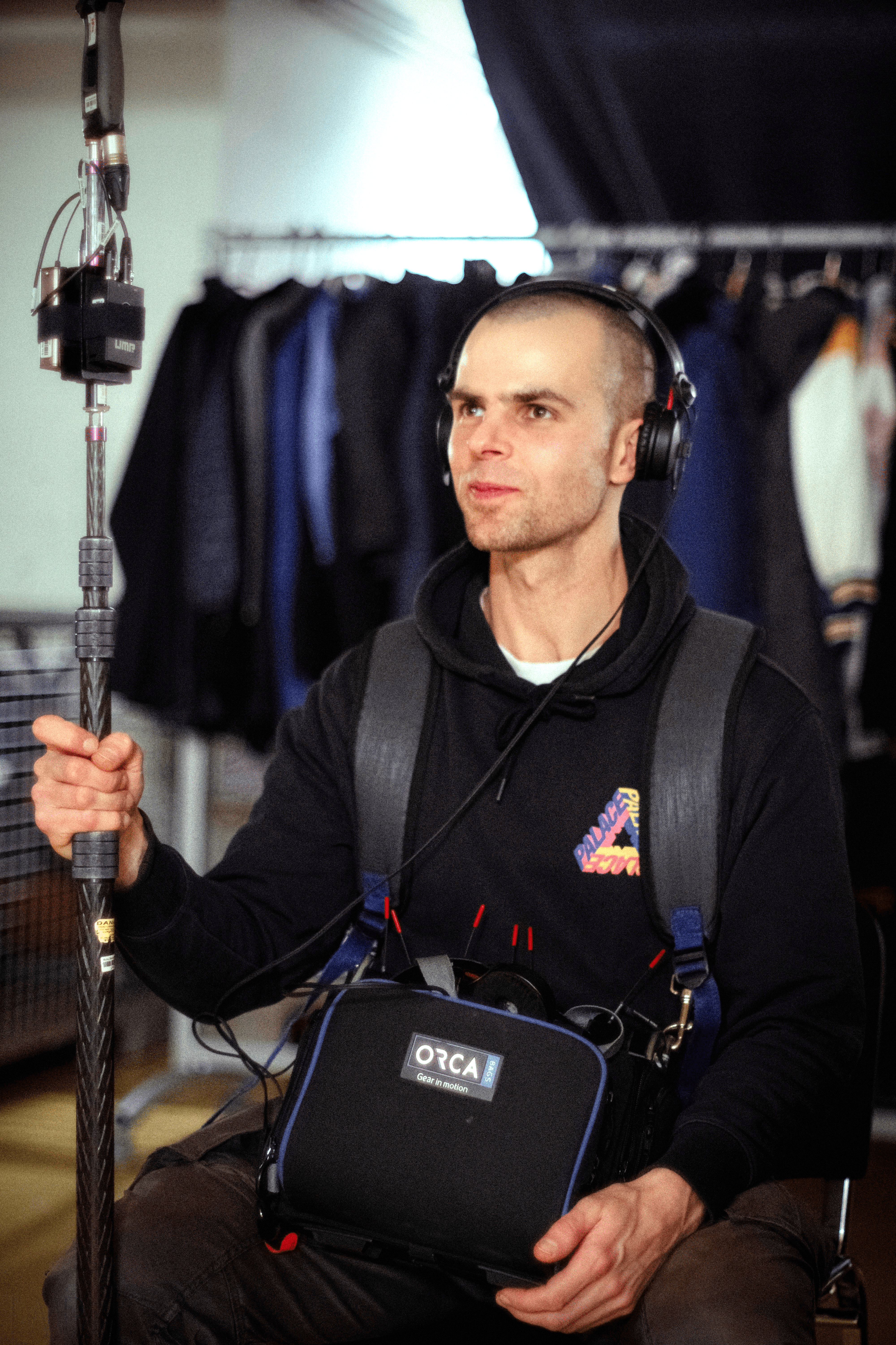 A woman with straight blonde hair wearing a light colored sweater looks away.