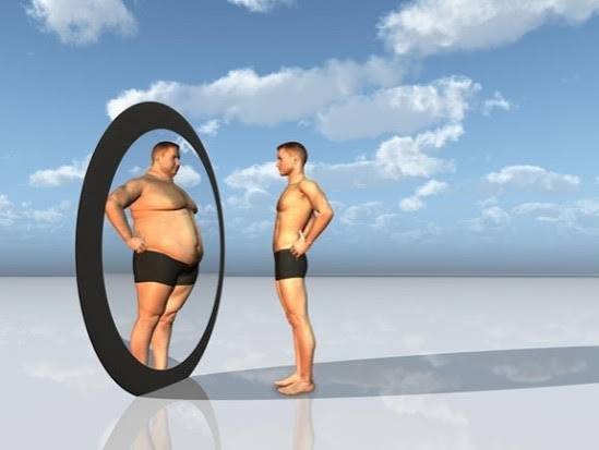 a man with body dysmorphia looking into a mirror