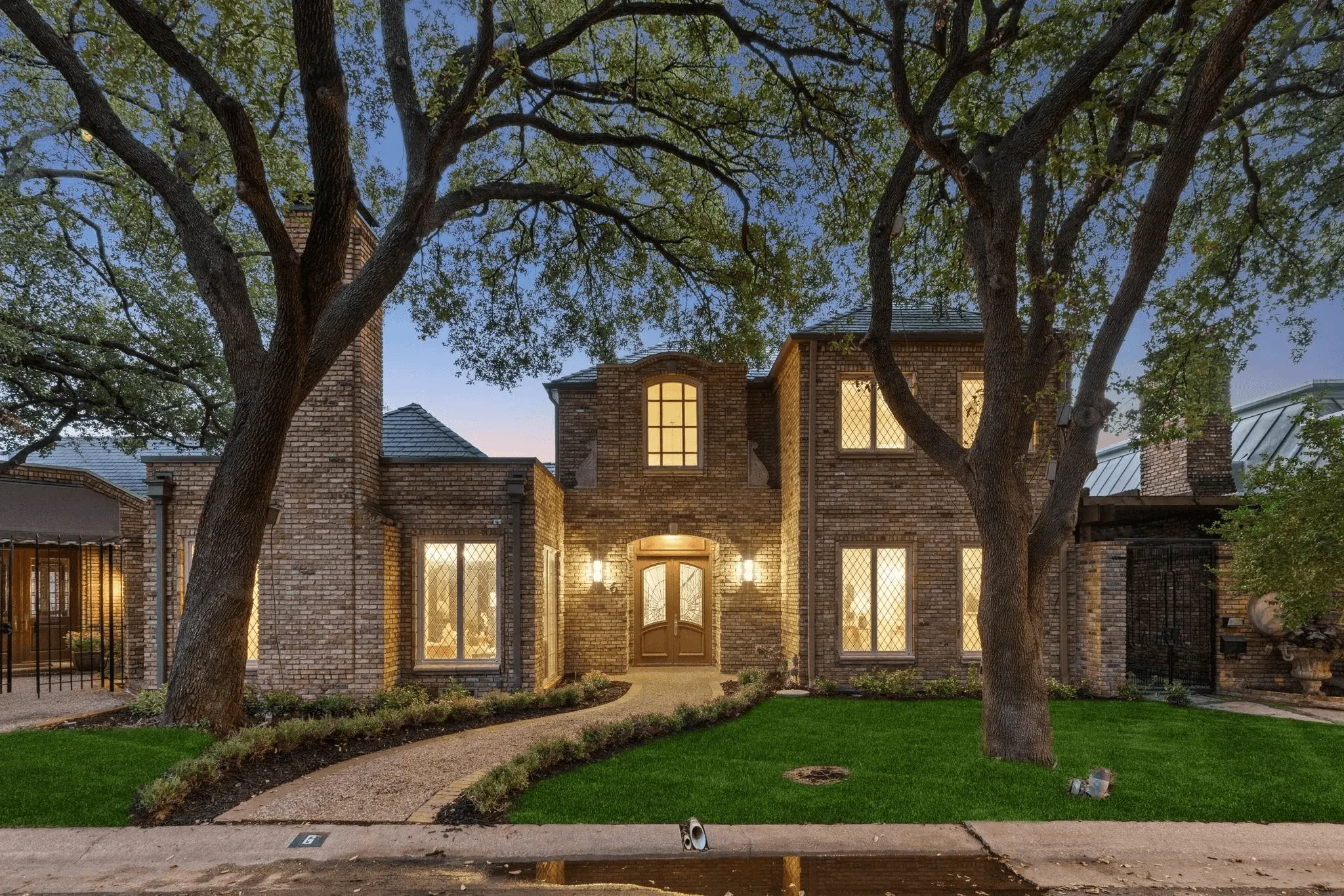 Front view of beautiful brick home in Corinth Texas featuring new F-Wave synthetic roof installation with mature landscaping