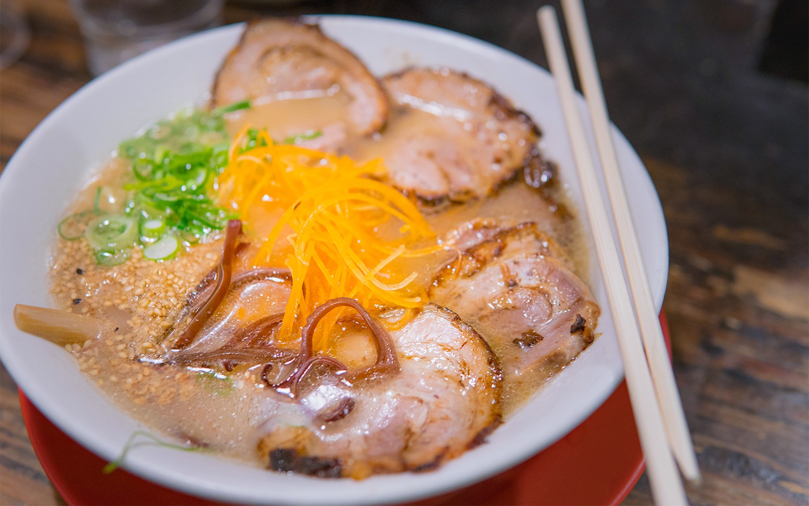 Bowl of ramen with sliced pork, green onions, and carrots, part of Nagoya tour cuisine experience.