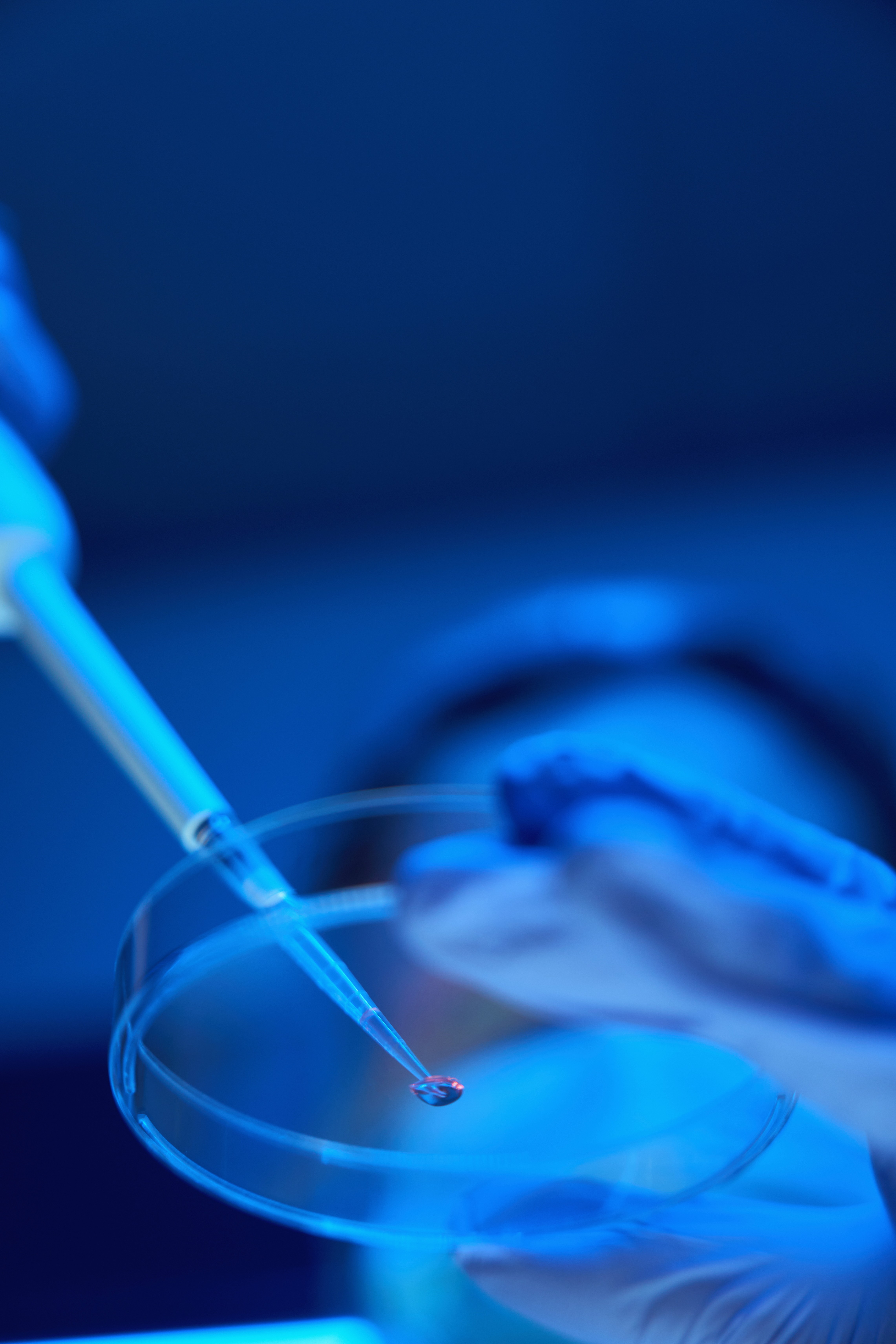a blue-lit room with a syringe and petri dish