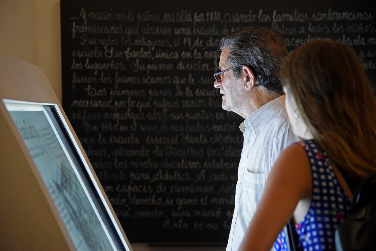 Hombre y mujer observando una pantalla interactiva en una exposición.