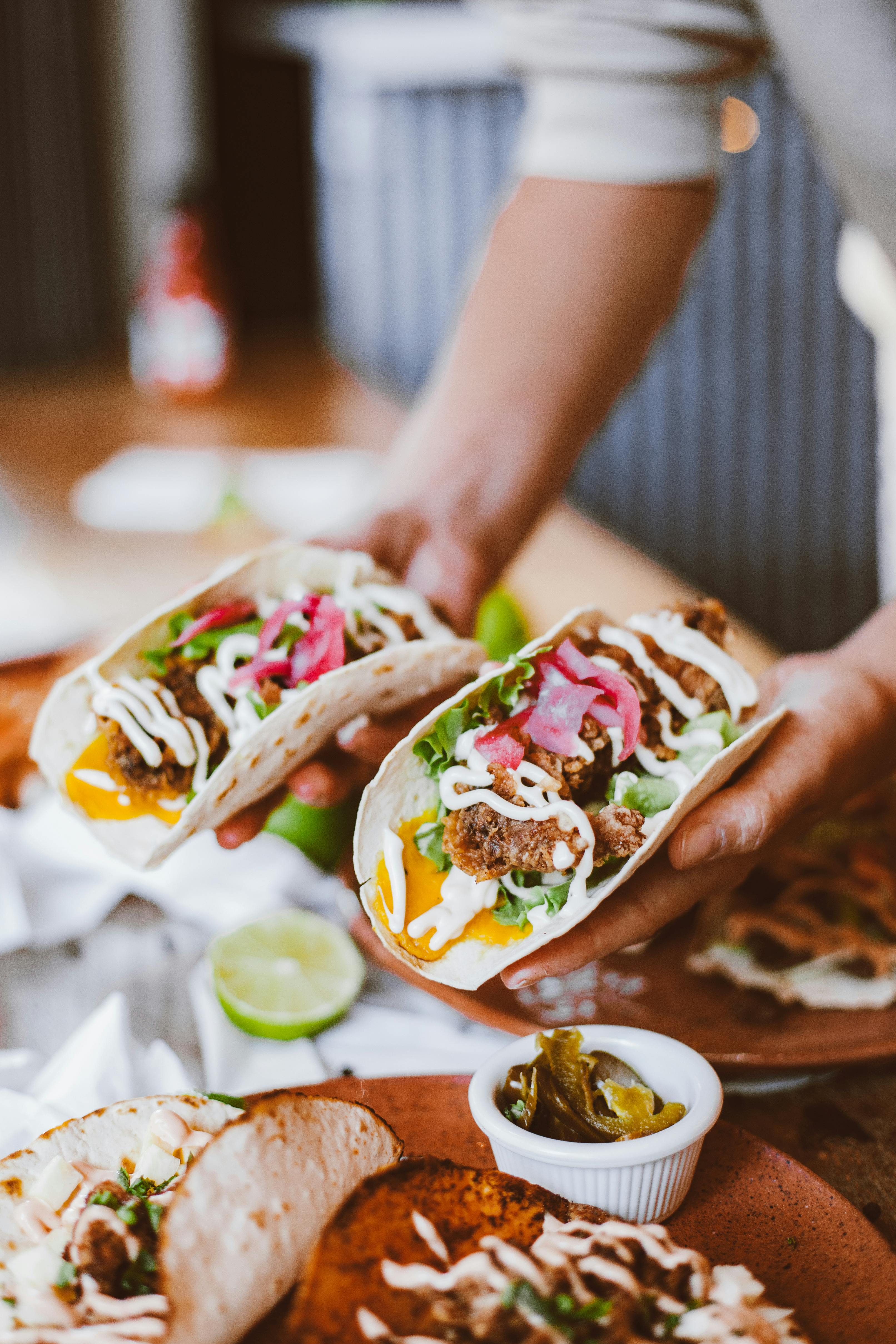 woman in purple shirt holding green and yellow floral ceramic bowl