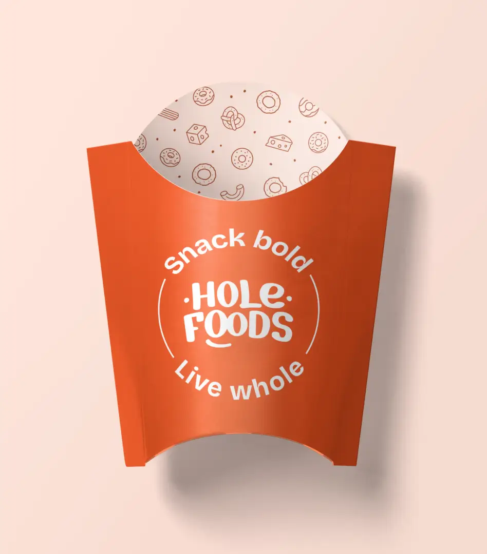 Orange Hole Foods snack sleeve packaging shaped like a fry container, printed with 'Snack bold, Live whole'.