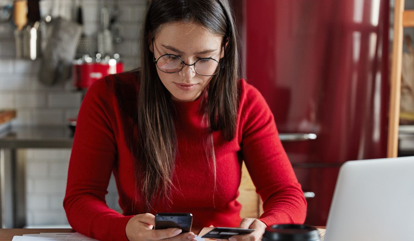 Imagem mostra mulher vendo contas em diferentes bancos no celular