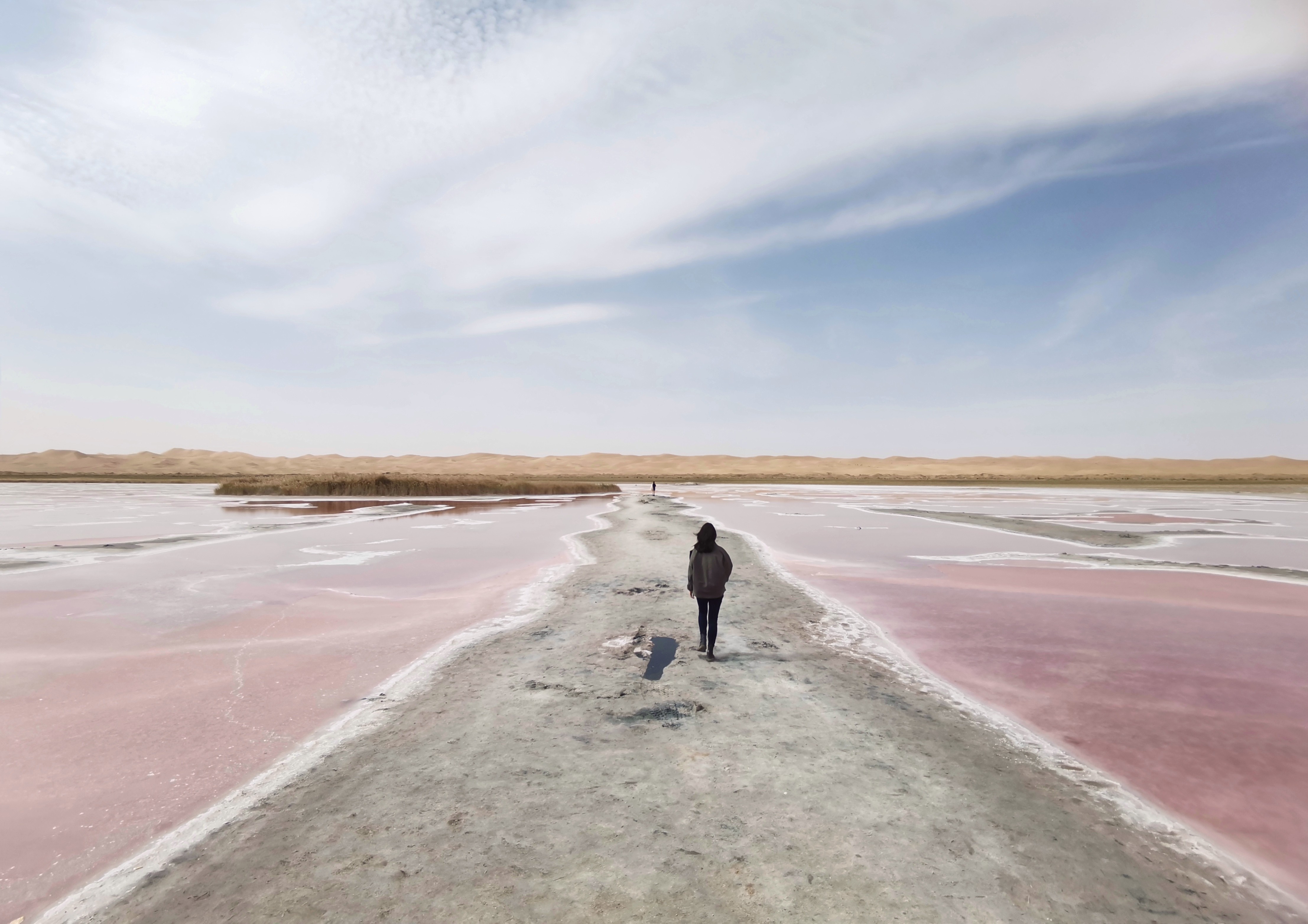 Black-and-white portrait of a Black person in a suit looking upward, shadow on white backdrop.